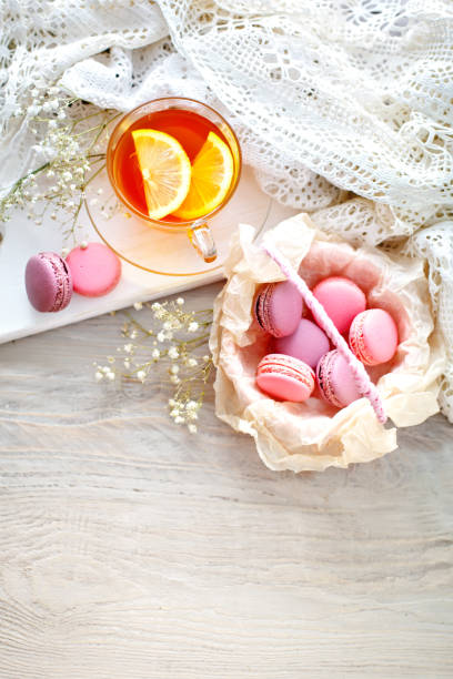 istock Tea with lemon, wild flowers and macaron on white wooden table 853124686
