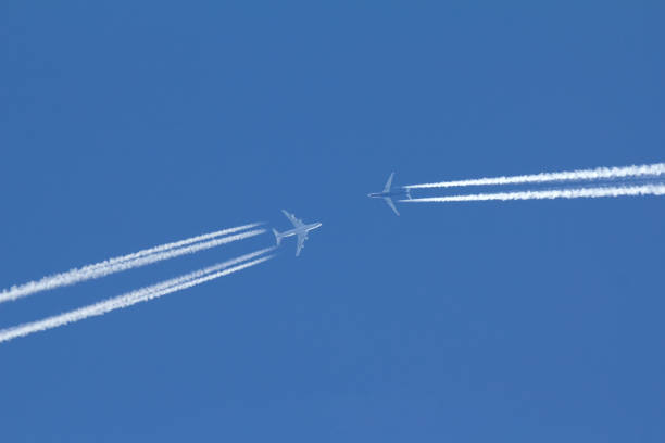 istock Two passengers airplanes are flying to each other in blue sky 853128934
