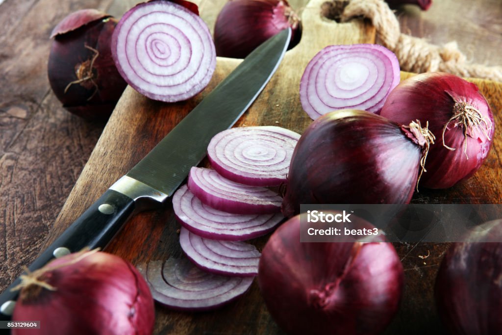 Red onions circles and red onions on board against wooden background Red onions circles and red onions on board Onion Stock Photo