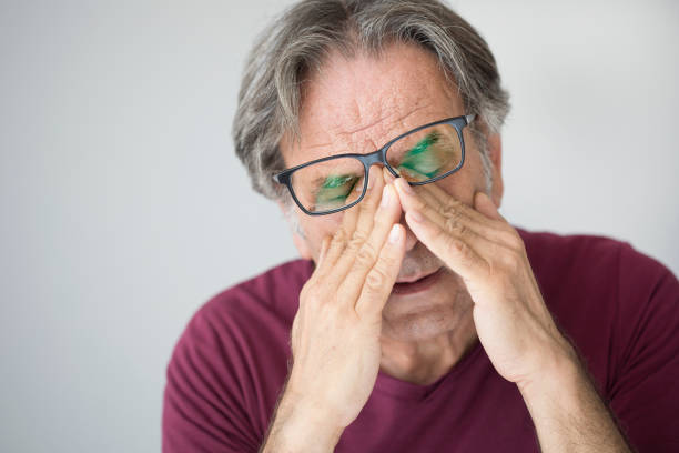 hombre con fatiga ocular - frotarse los ojos fotografías e imágenes de stock