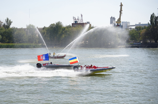 Rostov-on-Don, Russia- September 16,2017: Racers on speedboats rush in front of the audience at the day of the city of Rostov-on-Don. On the fire boat, workers make fountains