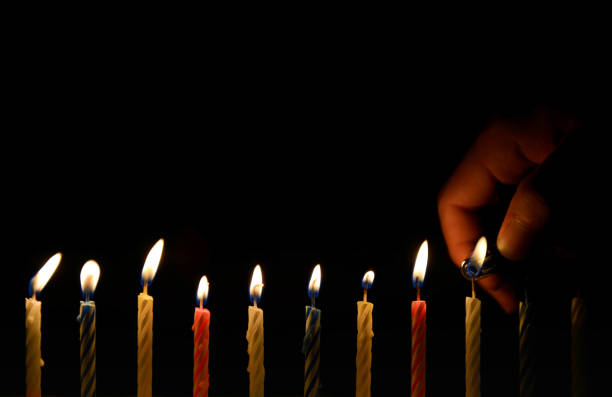 istock Human hand is lighting the birthday candle in the darkness 853159216