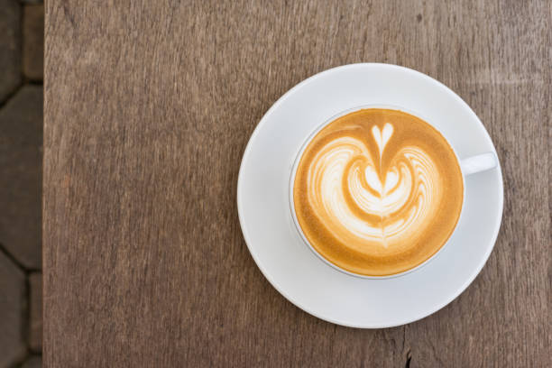 istock A white cup of coffee latte art on wood table 853160054