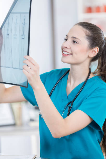 istock Cheerful veterinary nurse holds x-ray up to the light 853160600