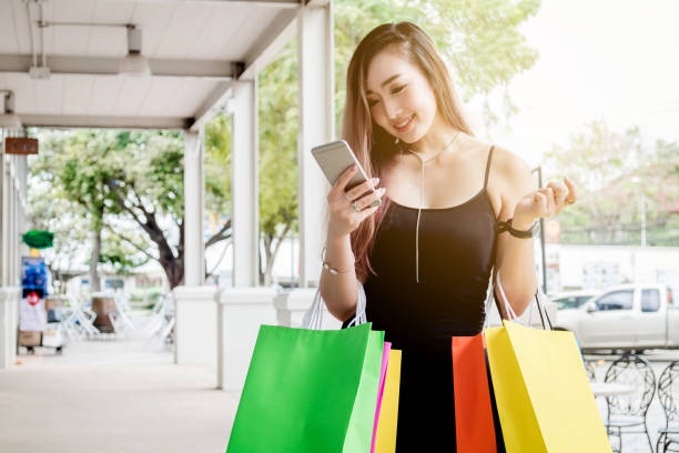 istock Woman using phone enjoying shopping Street 853166540