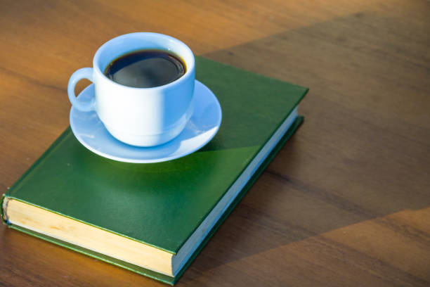 istock Cup of coffee and book on wooden table 853186106