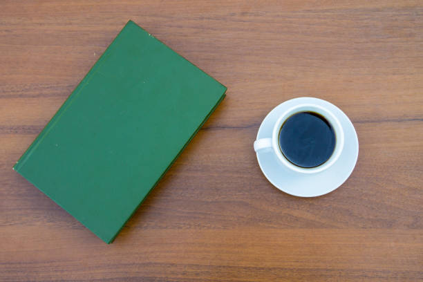 istock Cup of coffee and closed book on wooden table 853186142