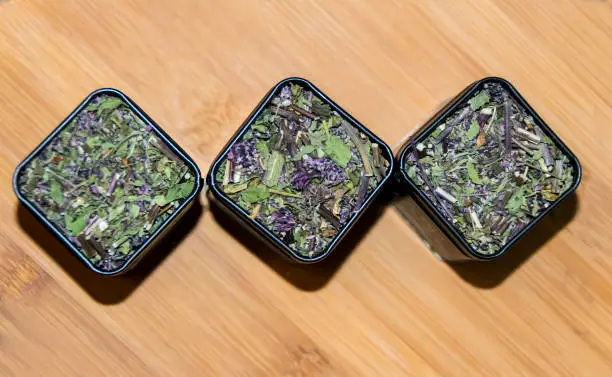 packing with dry green herbal tea on  wooden background