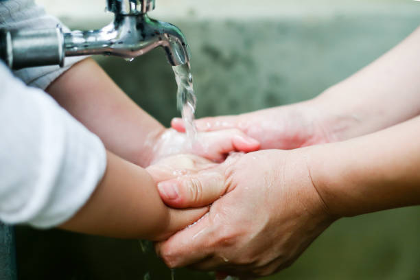 istock Stream of clean water pouring into children's hands 853215990