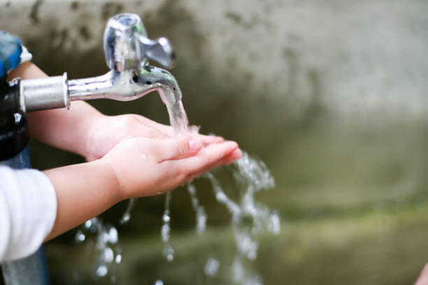 istock Stream of clean water pouring into children's hands 853216000