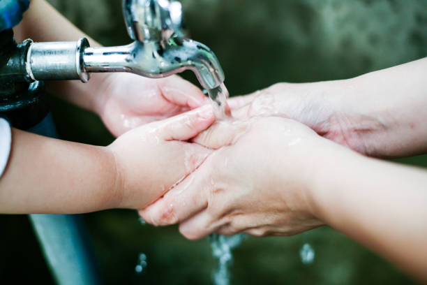 istock Stream of clean water pouring into children's hands 853216008