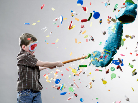 Boy pulsando piñata, explosión de caramelos photo
