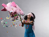 Girl hitting pinata, candy flying