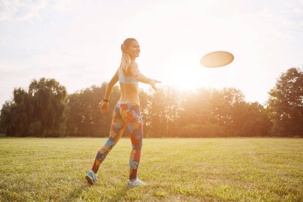 istock Young athletic girl playing with flying disc, ultimate 853234802