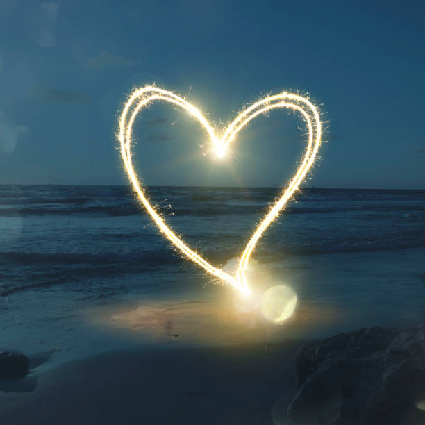 Heart Sparkle Sparkles in heart shape over sand at the beach glittering sea stock pictures, royalty-free photos & images