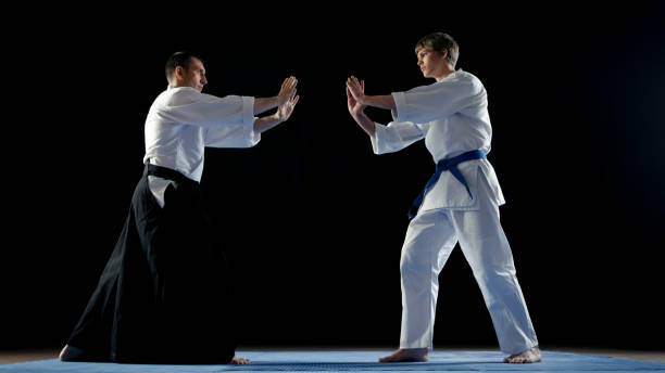istock Martial Arts Master Wearing Traditional Samurai Hakamas and His Young Student Take Battle Stance. Shot Isolated on Black Background. 853236964