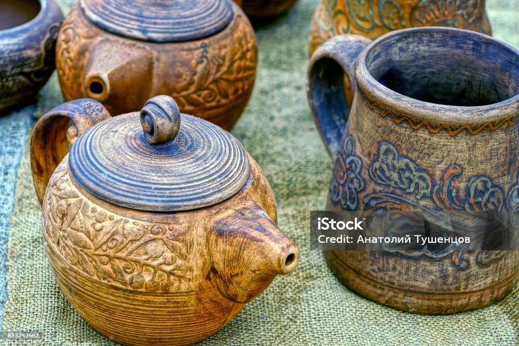 old wooden tableware on the table Mugs and a kettle of brown color on a gray table Antiquities Stock Photo