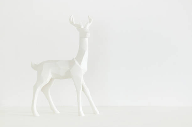 istock White reindeer on wooden table over white background 853252322