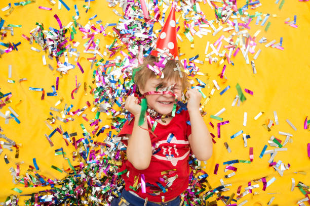 istock Happy kid celebrating party with blowing confetti top view 853258176
