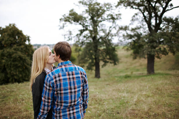 Young Caucasian heterosexual couple walking on the field in summer