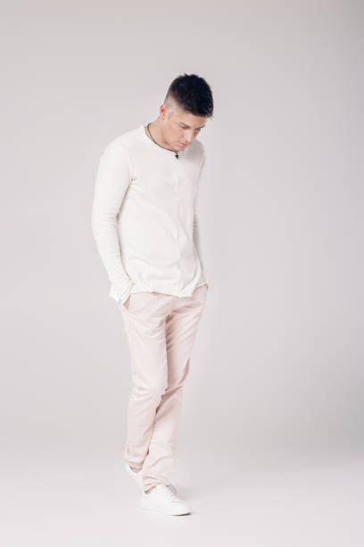 istock handsome young man in a white sweater and pants 853271436