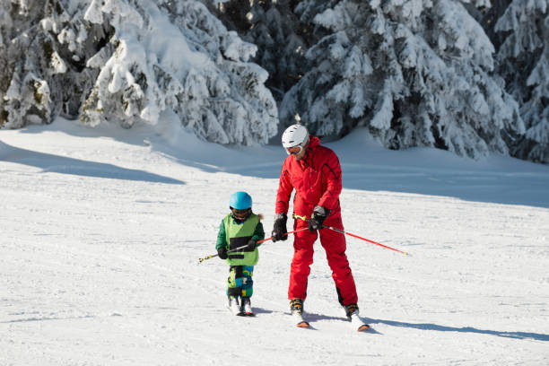 istock Little boy and ski trainer 853271882