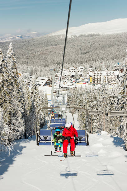 istock Ski instructor with little boy on ski lift 853274348