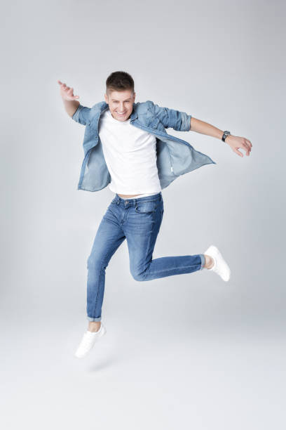 istock handsome man in jeans and jacket jumping 853274646