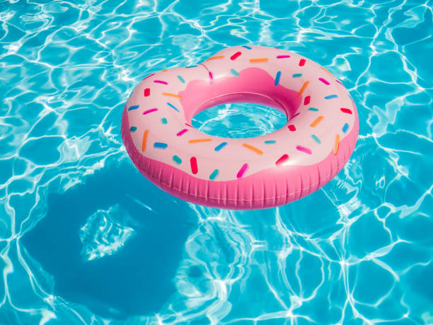 istock Pink inflatable donut swimming ring in a swimming pool 853275050