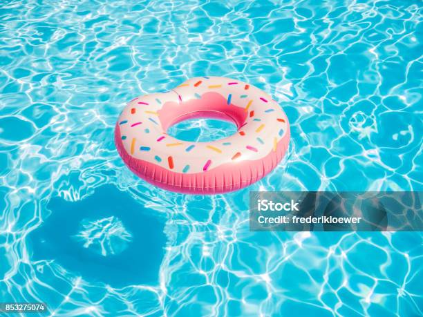 Photo libre de droit de Anneau De Natation Donut Gonflable Rose Dans Une Piscine banque d'images et plus d'images libres de droit de Piscine