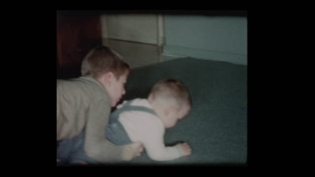 8 year old Little boy plays lovingly with baby brother 1960