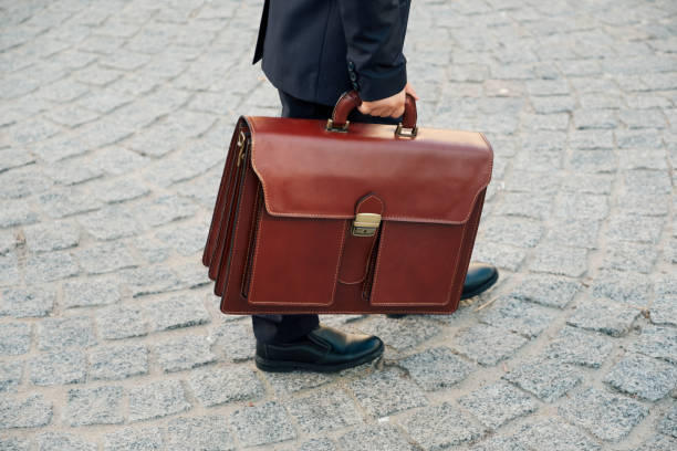 istock Hand holding business leather braun briefcase 853299954