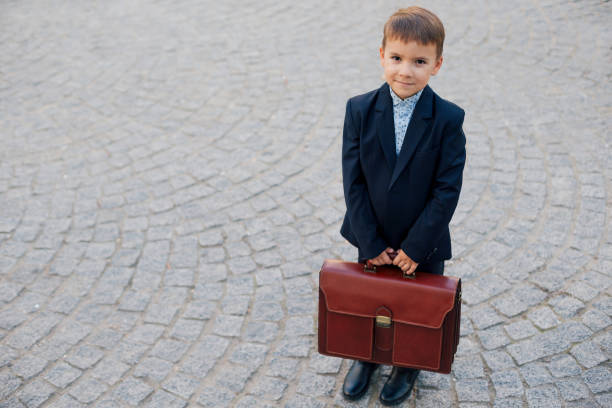 istock Smiling future businessman in formal costume with briefcase 853303644