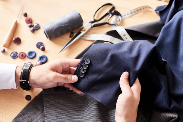 Fashion Designer Wrapped up in Work Close-up shot of talented young fashion designer working on male clothing collection while sitting at wooden table clothing design studio photos stock pictures, royalty-free photos & images