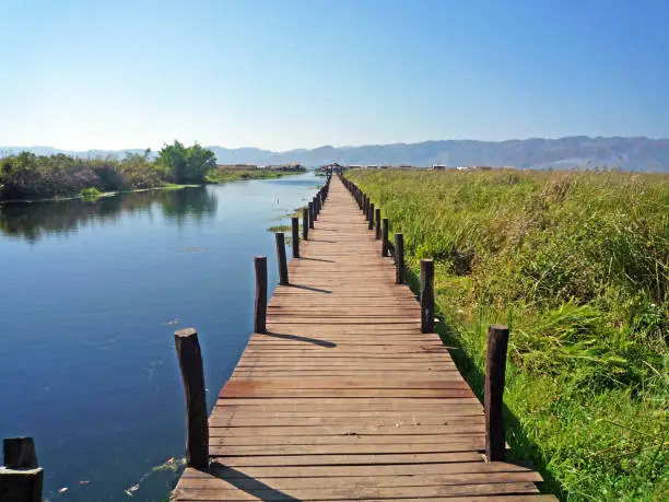 Long wooden bridge to go to a small village at Inle lake in Myanmar