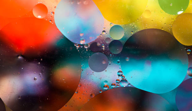 Macro oil and water multi colored abstract background Close up macro image depicting droplets of oil in water on a multi colored background. The oil forms interesting circles and spheres in the water, and colorful background produces and abstract effect. Horizontal color image with copy space. geometry photos stock pictures, royalty-free photos & images