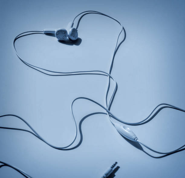 White wired Headphones and red heart on a blue background. Entertainment concept