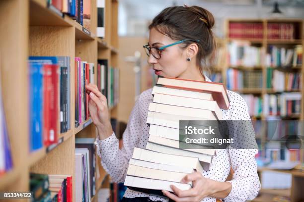 Young Woman With A Stack Of Books In Library Want More Stock Photo - Download Image Now