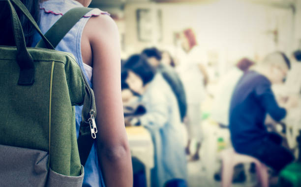 Girl with backpack entering to the art classroom.