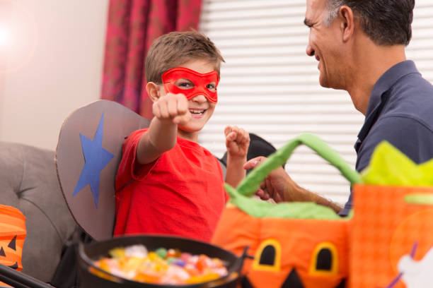 istock Little boy dresses up for Halloween with dad's help. 853353888