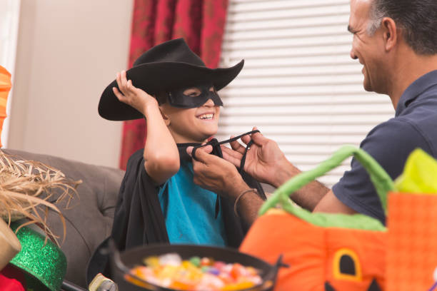 istock Little boy dresses up for Halloween with dad's help. 853354192