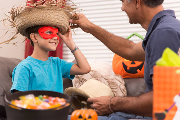 istock Little boy dresses up for Halloween with dad's help. 853354498