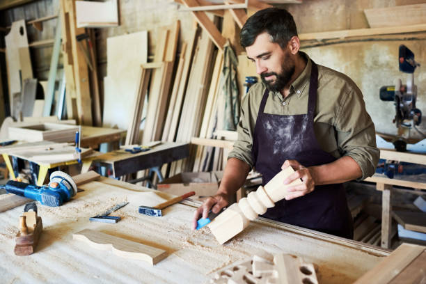 istock Bearded Carpenter Carving Stair Posts in Shop 853360508