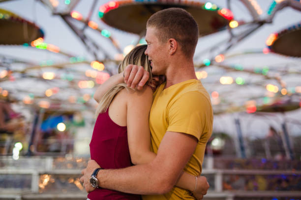 istock Couple embracing at amusement park 853374802