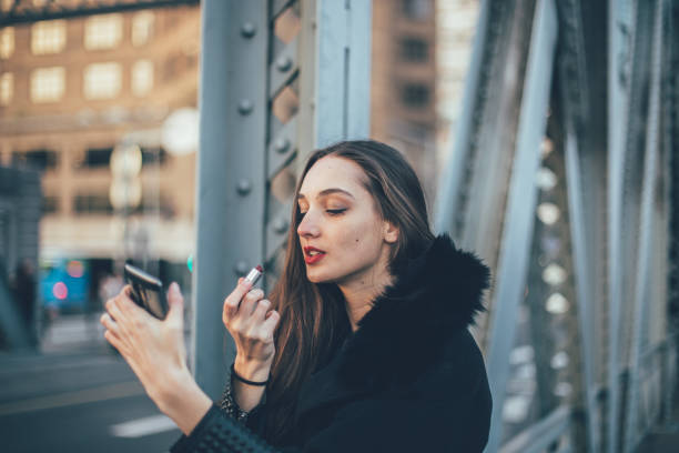 istock Girl on the bridge putting lipstick 853374960