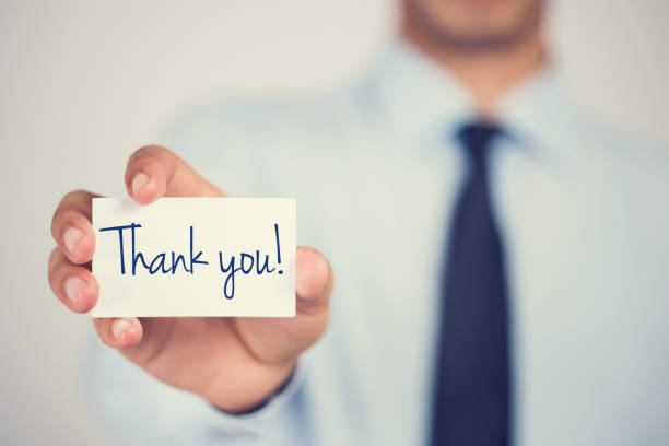 Thank you word on card hold by man stock photo