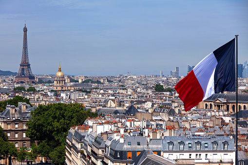 French flag waving on the roof of the Pantheon with behind, the Eiffel Tower, the Invalides, La Défense and the Saint Sulpice church.