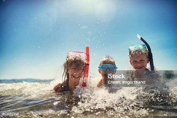 Kids Having Fun Snorkeling In Beautiful Sea Stock Photo - Download Image Now - Snorkeling, Child, Sea