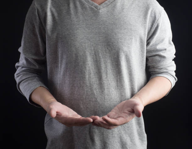 istock Young man giving empty hand on black background.Hands open businessman. some object are here. 853405556