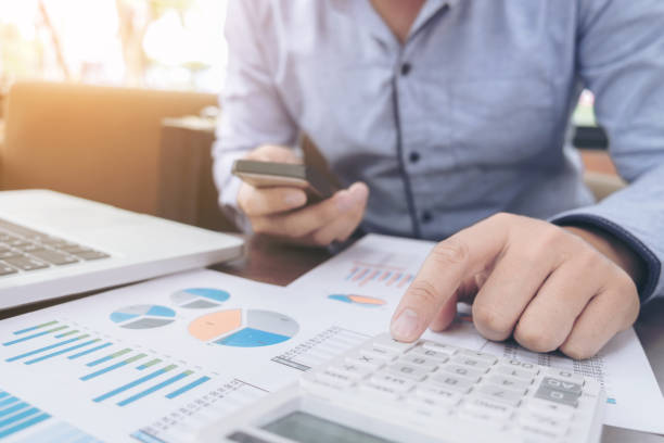 istock Business Financing Accounting Banking Concept, businessman using smart phone and doing finances, calculate about cost to real estate investment and in other, tax system 853407114